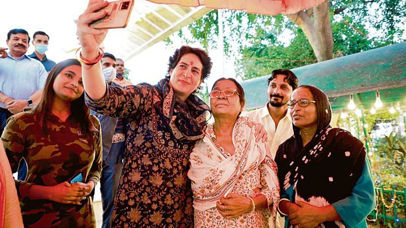 Congress leader Priyanka Gandhi clicks a picture with supporters during her visit to Valmiki temple in New Delhi on Thursday. PTI